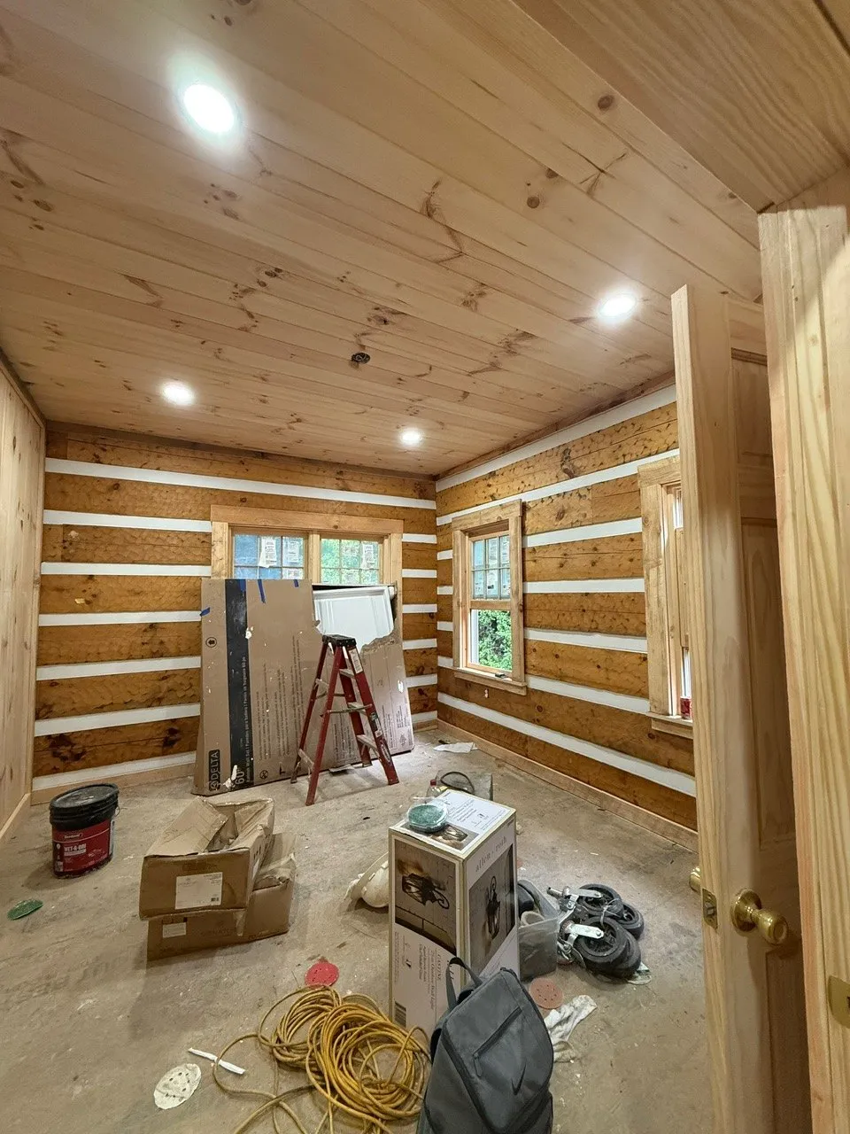 Log cabin bedroom with recessed lights in a pine ceiling