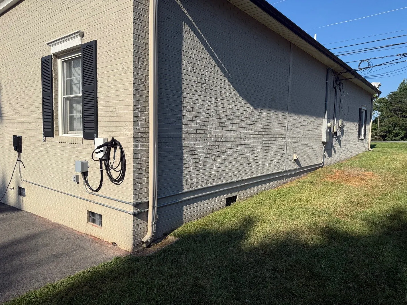 Electric vehicle charger mounted on the side of a brick house
