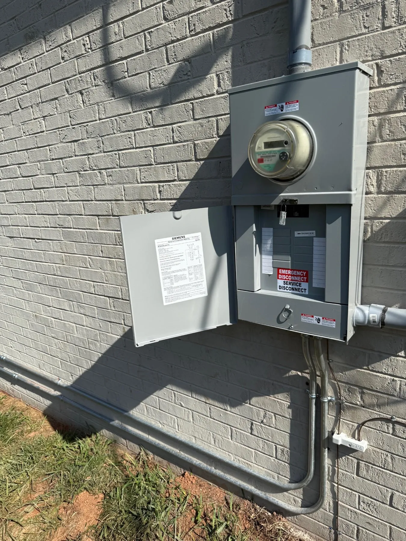 New meter and service disconnect panel on a brick wall