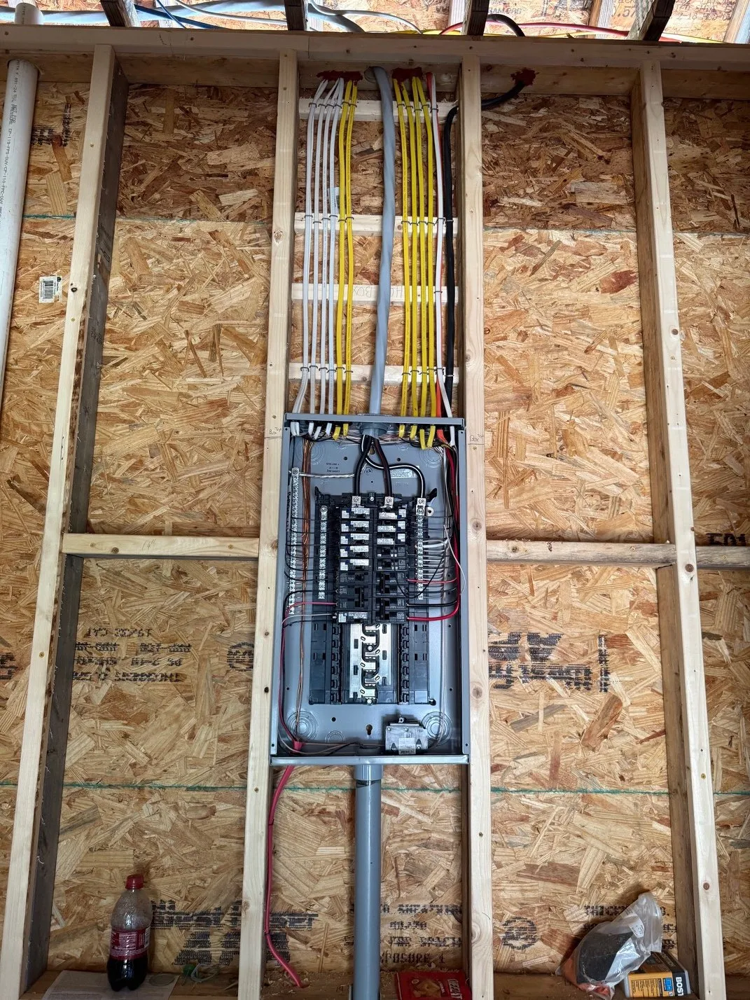 New electrical panel with neatly run wiring in a framed wall