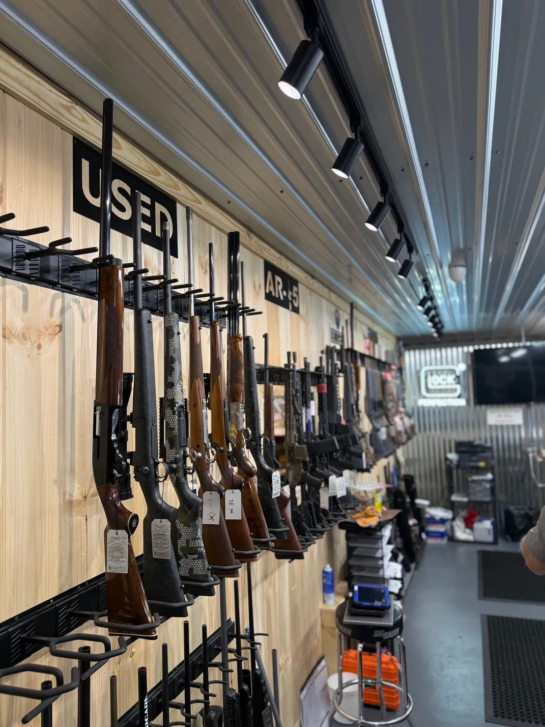 Store wall lit by a long run of black track lights